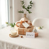 Neatly arranged fashion and self-care gifts on a clean tabletop with soft natural light