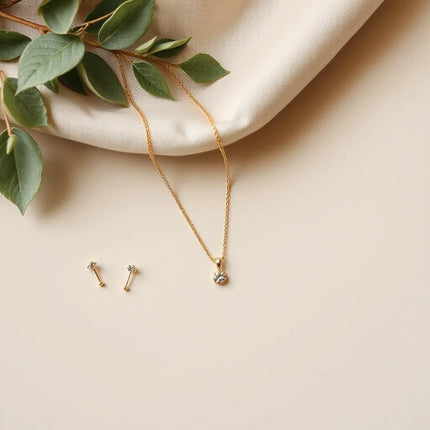 Gold necklace, stud earrings, and bracelet arranged neatly on a light background