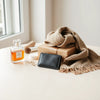Curated set of stylish gifts for women, including jewelry, perfume, a scarf, and a skincare set on a neutral table.