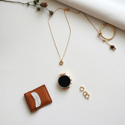 Minimalist jewelry and accessories arranged neatly on a light linen background