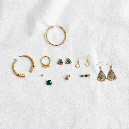Assorted unique earrings for women displayed on a neutral fabric background