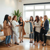 Diverse women in stylish outfits gather in a bright community space and share fashion ideas