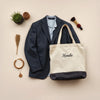 Folded tailored jacket and custom accessories with fabric swatches arranged on a neutral background