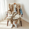 Neutral chic everyday outfit pieces laid out with blazer, denim, trousers, and minimalist accessories