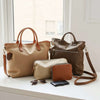Curated set of everyday bags—tote, crossbody, and shoulder bag—with small essentials on a neutral surface.