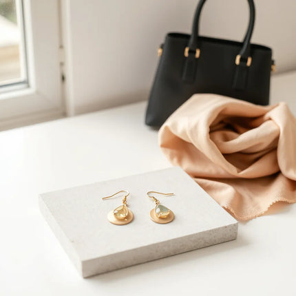 Elegant statement earrings displayed with a silk scarf and minimal accessories on a neutral surface