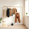 Neatly arranged women’s wardrobe essentials in a cohesive neutral color palette with a handbag and accessories