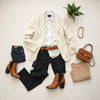Neutral flat-lay of tailored blazer, crisp shirt, dark jeans, belt, boots, and handbag