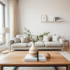 Bright living room styled with textured pillows, modern vase, fresh greenery, and warm natural light