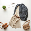 Neatly styled assortment of versatile clothing and accessories on a light neutral background