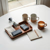 Neatly arranged everyday essentials—keys, wallet, notebook, pen, mug, and water bottle—in soft natural light