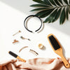 Assorted trendy hair accessories like headbands, clips, and a satin scrunchie arranged on a minimalist vanity