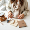 A curated selection of everyday fashion and lifestyle essentials on a neutral table with soft natural light