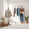 Neatly styled seasonal outfits on a minimal clothing rack with light jacket, knitwear, scarf, and boots