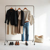 Curated womens outfits on a clothing rack with blazer, dress, sweater, jeans, and accessories
