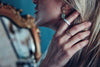 a woman with a cigarette in her hand and a mirror in the background
