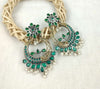 a close up of a pair of green and white earrings